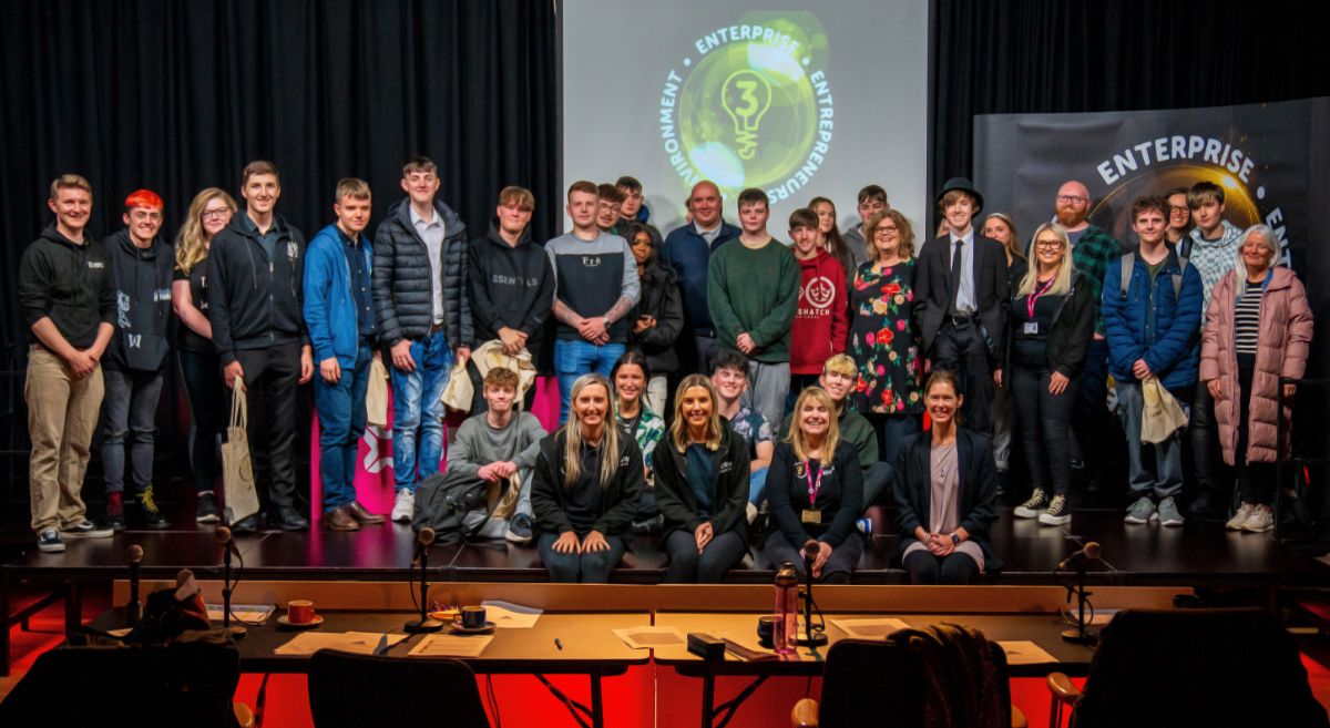 Group of staff and students on a stage